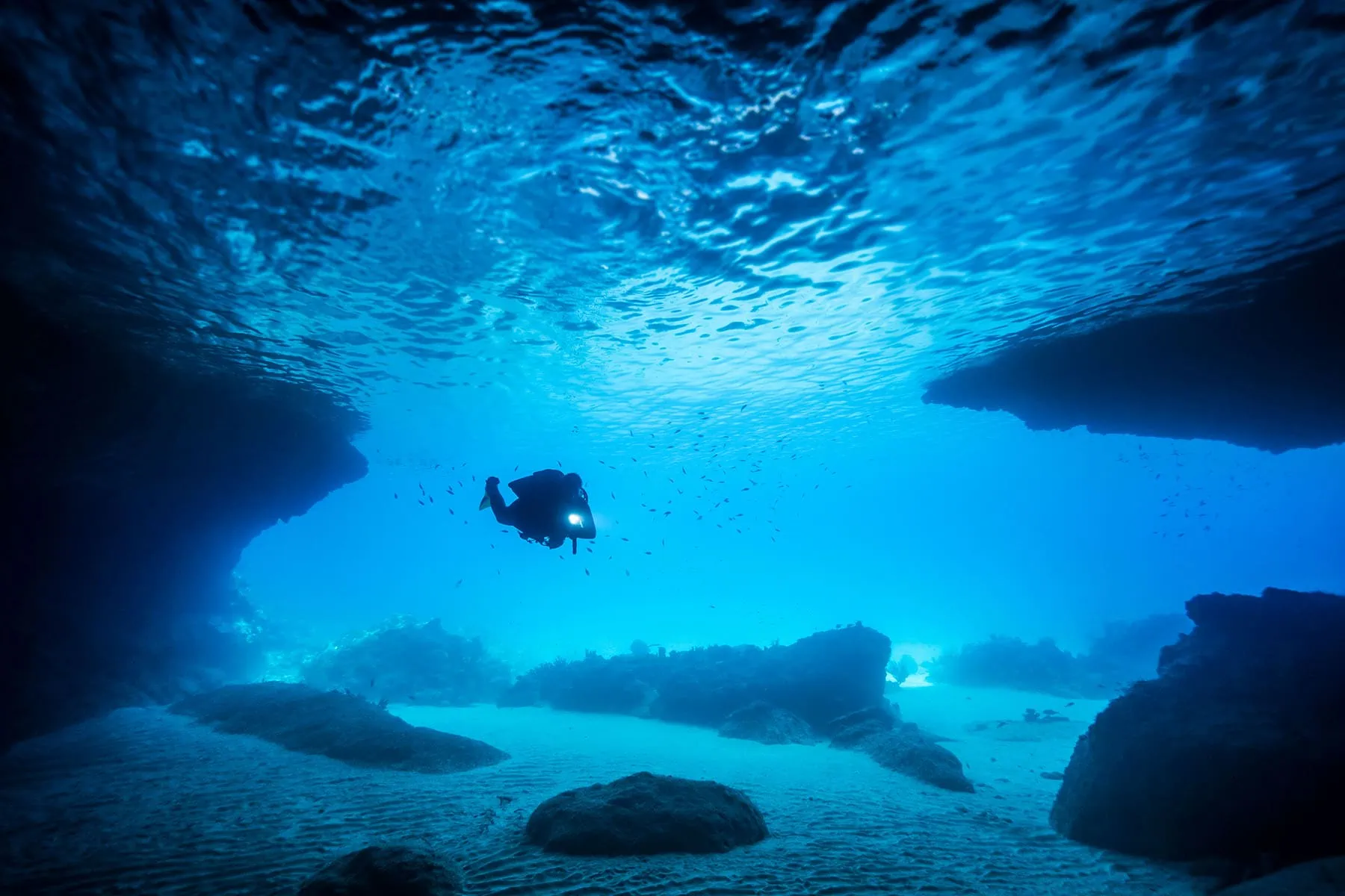 En dykare omgiven av blått hav på Curacao