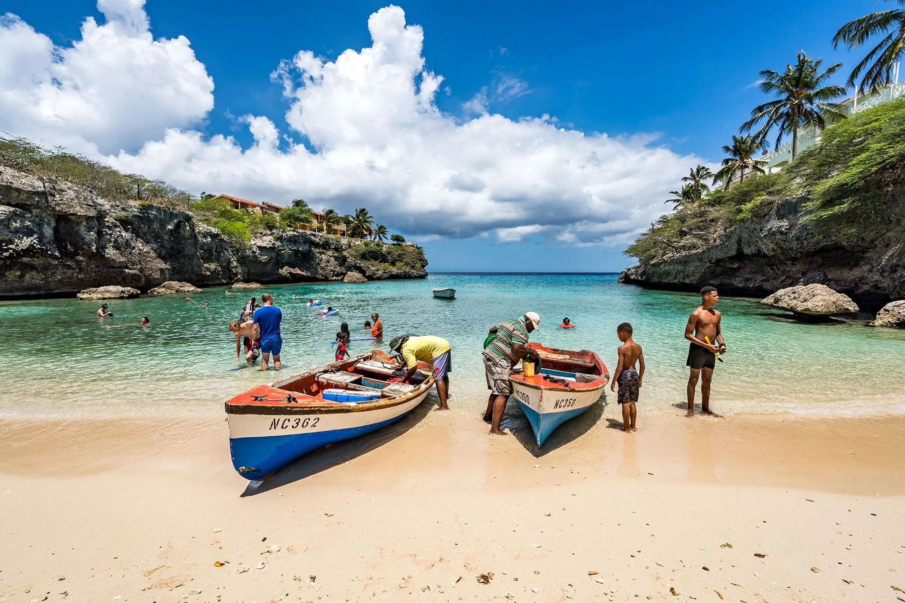 En strand på Curacao med fiskare och en fiskbåt