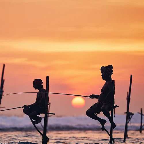 Två fiskare på Sri Lanka i solnedgången