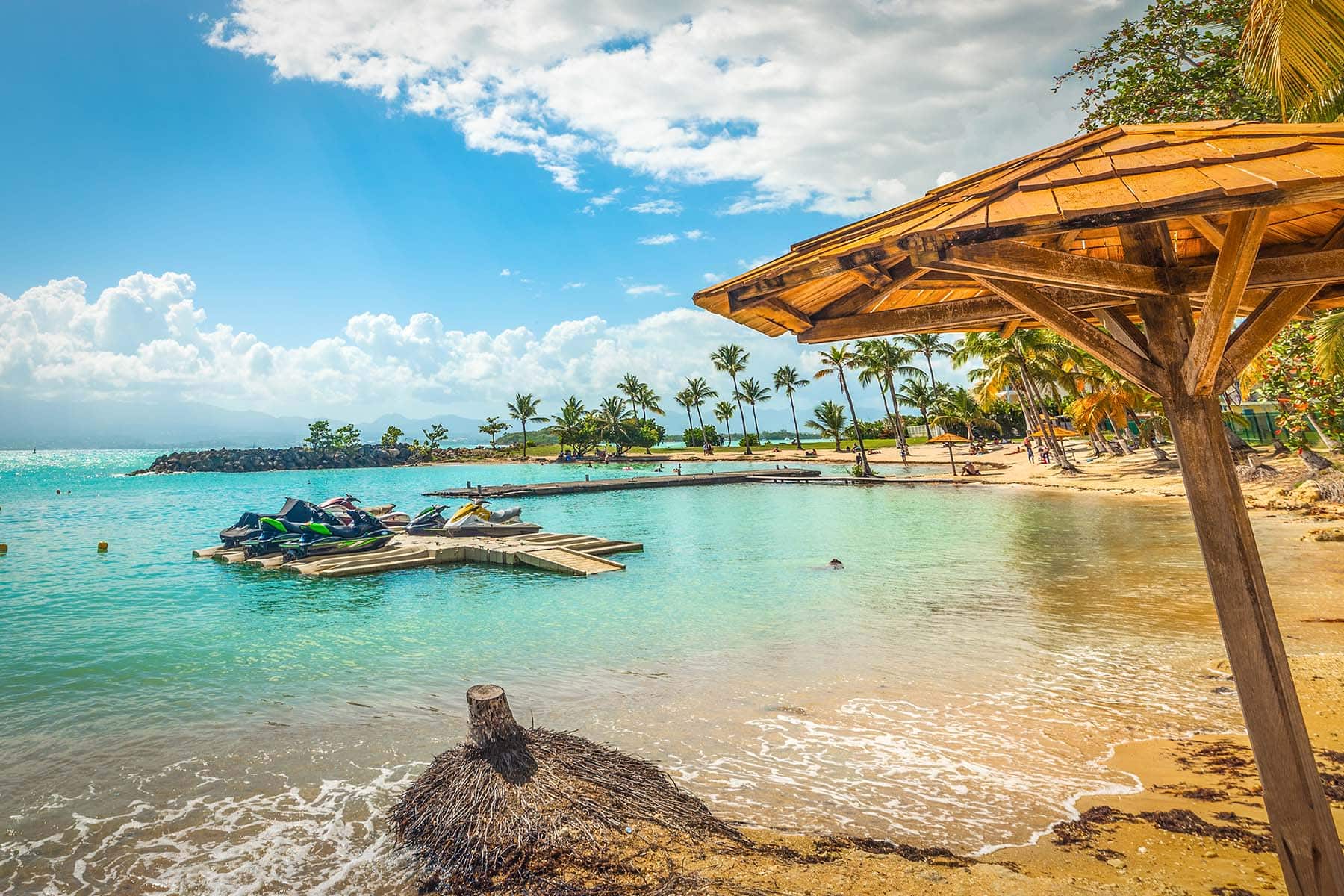 en strand i Västindien med en parasoll och vattenscooter